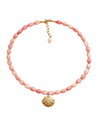 Necklace with pink beads and a gold shell pendant on a white background